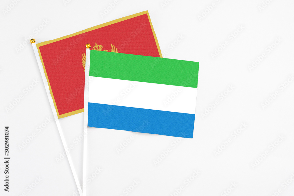 Sierra Leone and Montenegro stick flags on white background. High quality fabric, miniature national flag. Peaceful global concept.White floor for copy space. Sierra Leone and Montenegro stick flags on white background. High quality fabric, miniature national flag. Peaceful global concept.White floor for copy space.