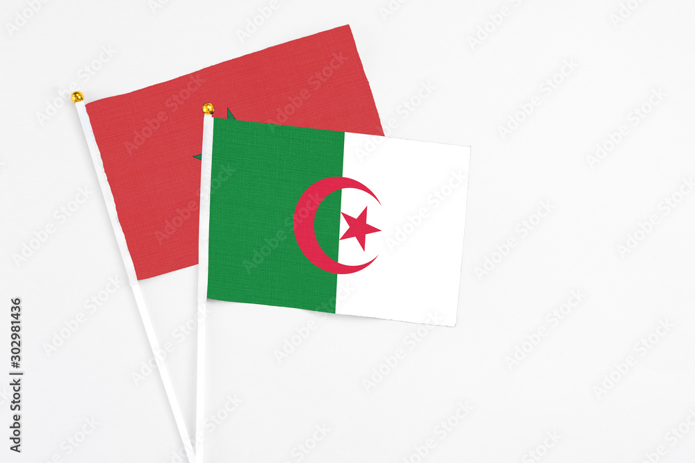 Algeria and Morocco stick flags on white background. High quality fabric, miniature national flag. Peaceful global concept.White floor for copy space. Algeria and Morocco stick flags on white background. High quality fabric, miniature national flag. Peaceful global concept.White floor for copy space.
