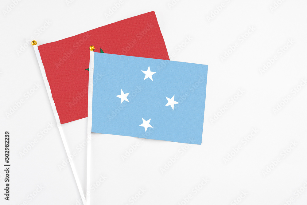 Micronesia and Morocco stick flags on white background. High quality fabric, miniature national flag. Peaceful global concept.White floor for copy space. Micronesia and Morocco stick flags on white background. High quality fabric, miniature national flag. Peaceful global concept.White floor for copy space.
