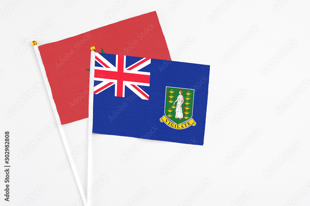 Fototapeta premium British Virgin Islands and Morocco stick flags on white background. High quality fabric, miniature national flag. Peaceful global concept.White floor for copy space.