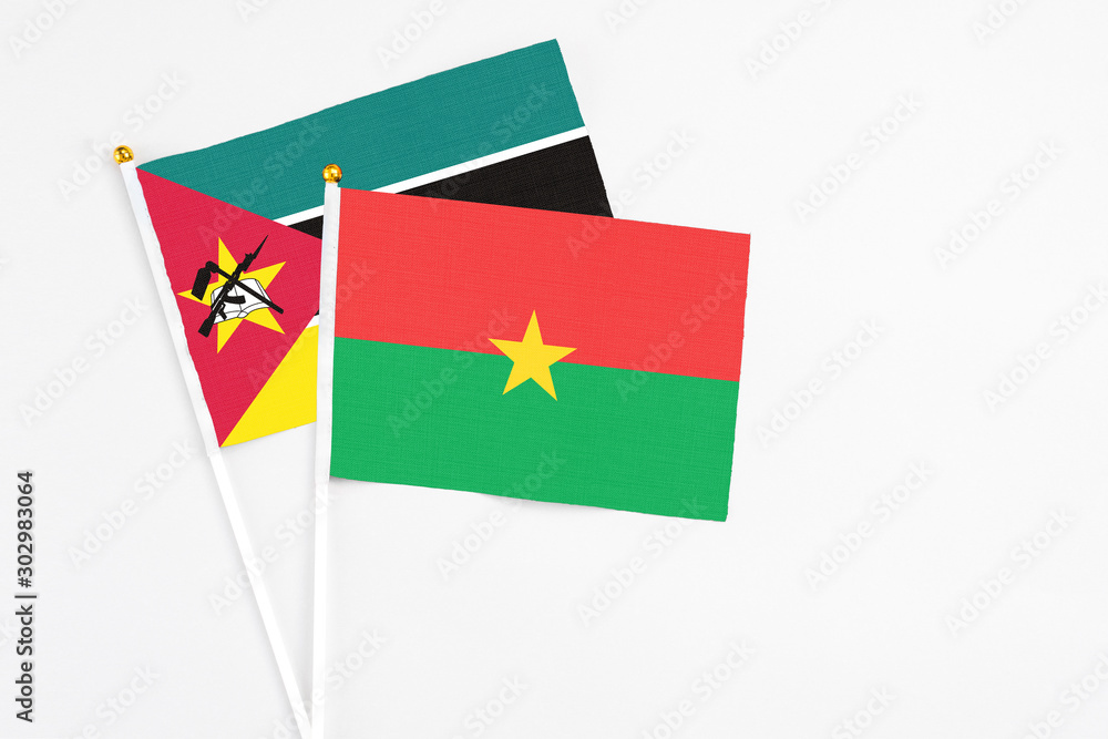 Burkina Faso and Mozambique stick flags on white background. High quality fabric, miniature national flag. Peaceful global concept.White floor for copy space. Burkina Faso and Mozambique stick flags on white background. High quality fabric, miniature national flag. Peaceful global concept.White floor for copy space.