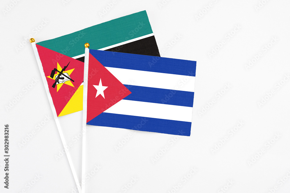 Cuba and Mozambique stick flags on white background. High quality fabric, miniature national flag. Peaceful global concept.White floor for copy space. Cuba and Mozambique stick flags on white background. High quality fabric, miniature national flag. Peaceful global concept.White floor for copy space.