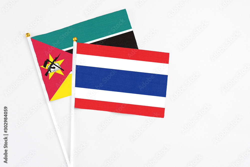 Thailand and Mozambique stick flags on white background. High quality fabric, miniature national flag. Peaceful global concept.White floor for copy space. Thailand and Mozambique stick flags on white background. High quality fabric, miniature national flag. Peaceful global concept.White floor for copy space.