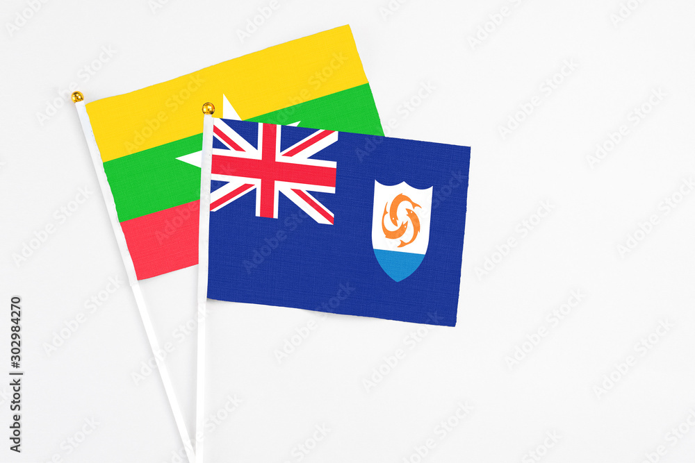 Fototapeta premium Anguilla and Myanmar stick flags on white background. High quality fabric, miniature national flag. Peaceful global concept.White floor for copy space.