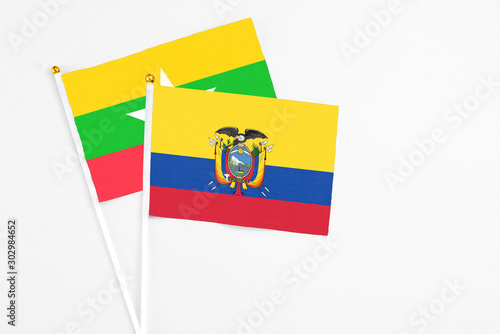 Ecuador and Myanmar stick flags on white background. High quality fabric, miniature national flag. Peaceful global concept.White floor for copy space.
