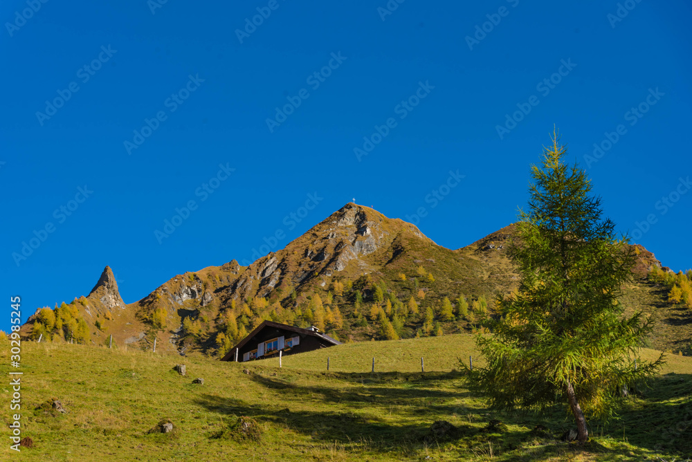landscape in mountains, hut, peak and blue sky 