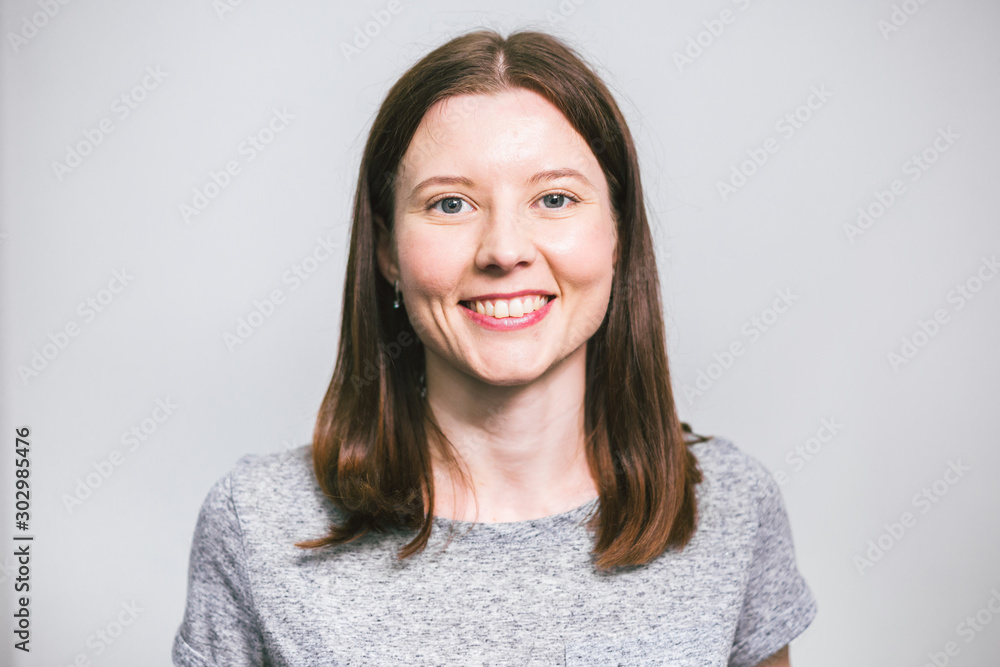 portrait of stylish young pretty Caucasian woman smiling in grey t-shirt on white studio background, isolated, natural look, long brown hair portrait of stylish young pretty Caucasian woman smiling in grey t-shirt on white studio background, isolated, natural look, long brown hair