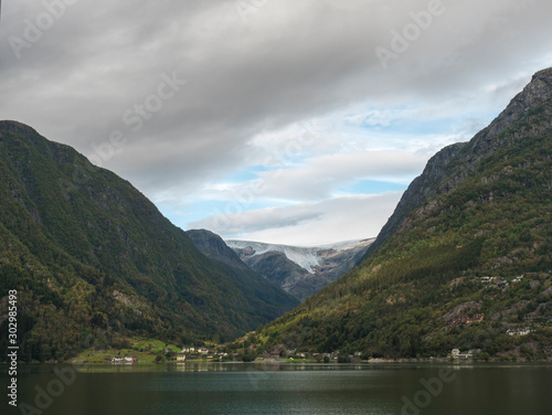 View over blue water of Hardanger Fjord in Kinsarvik on folgefonna glacier with small village on the coast. Norway nature and travel background. Early autumn day. © Kristyna