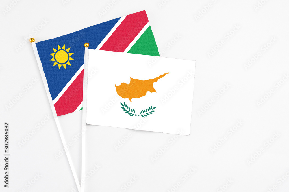 Obraz premium Cyprus and Namibia stick flags on white background. High quality fabric, miniature national flag. Peaceful global concept.White floor for copy space.