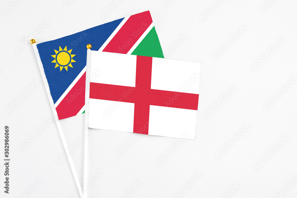 England and Namibia stick flags on white background. High quality fabric, miniature national flag. Peaceful global concept.White floor for copy space.