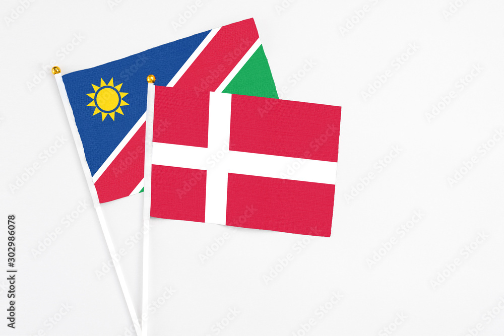 Denmark and Namibia stick flags on white background. High quality fabric, miniature national flag. Peaceful global concept.White floor for copy space.