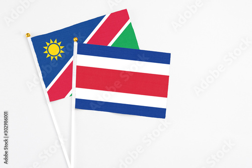 Costa Rica and Namibia stick flags on white background. High quality fabric, miniature national flag. Peaceful global concept.White floor for copy space. photo