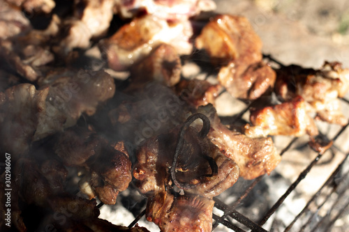 Cooking shish kebabs on the grill on the coals. Appetizing pieces of meat are fried on skewers. Kebabs are fried on coals