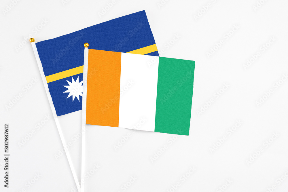 Cote D'Ivoire and Nauru stick flags on white background. High quality fabric, miniature national flag. Peaceful global concept.White floor for copy space. Cote D'Ivoire and Nauru stick flags on white background. High quality fabric, miniature national flag. Peaceful global concept.White floor for copy space.