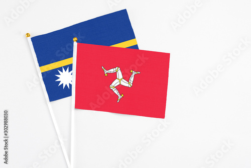 Isle Of Man and Nauru stick flags on white background. High quality fabric, miniature national flag. Peaceful global concept.White floor for copy space.