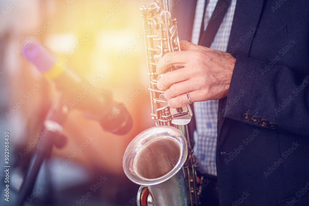 Obraz premium Jazz man musician playing saxophone with sun light
