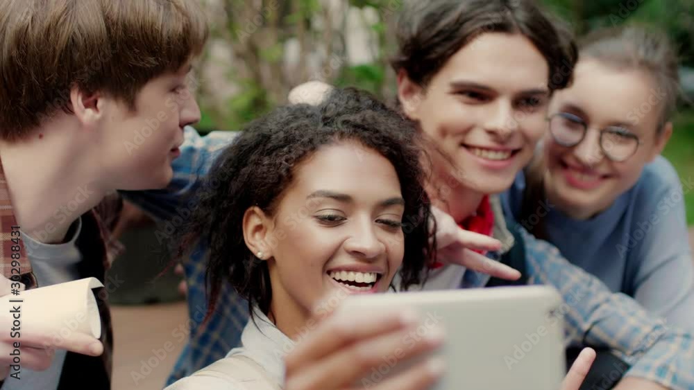 Close up shot of young casual multinational students joyfully taking selfie on cellphone in university campus outdoor Close up shot of young casual multinational students joyfully taking selfie on cellphone in university campus outdoor