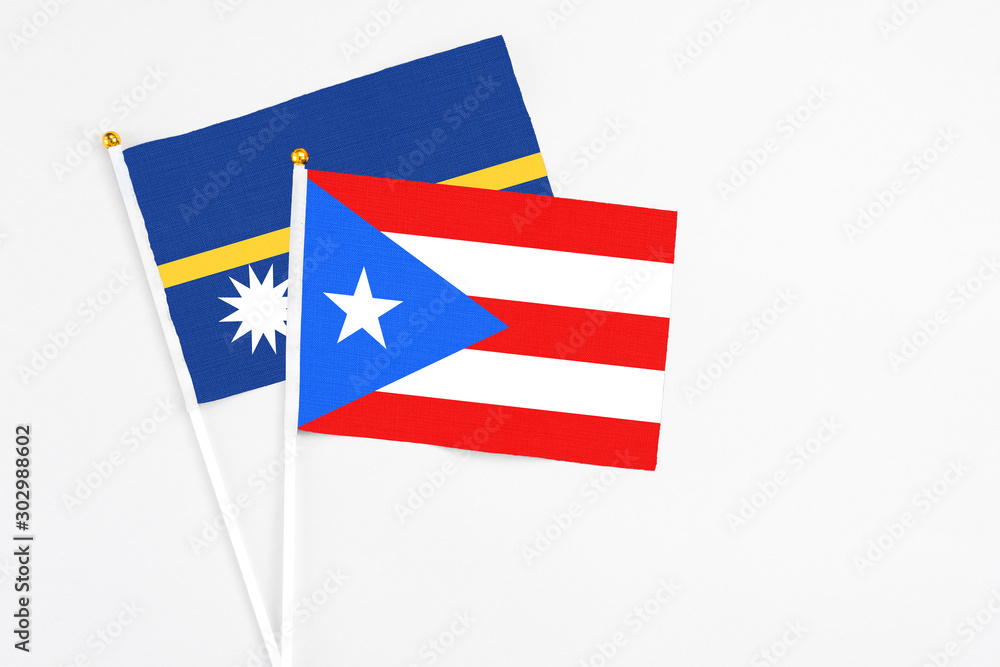 Puerto Rico and Nauru stick flags on white background. High quality fabric, miniature national flag. Peaceful global concept.White floor for copy space.