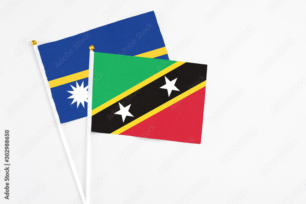 Saint Kitts And Nevis and Nauru stick flags on white background. High quality fabric, miniature national flag. Peaceful global concept.White floor for copy space. Saint Kitts And Nevis and Nauru stick flags on white background. High quality fabric, miniature national flag. Peaceful global concept.White floor for copy space.