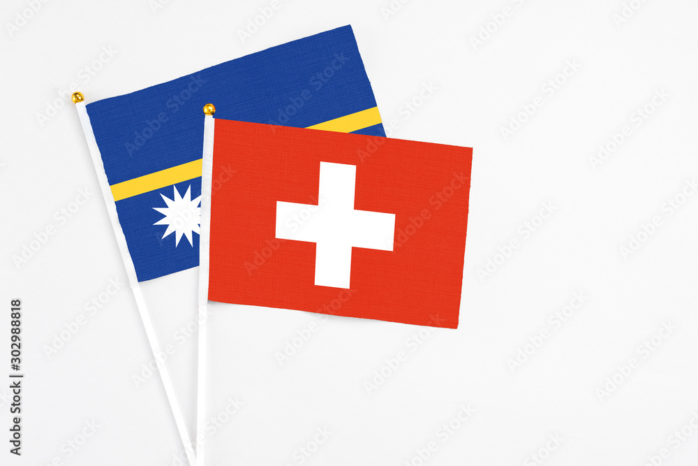 Switzerland and Nauru stick flags on white background. High quality fabric, miniature national flag. Peaceful global concept.White floor for copy space.