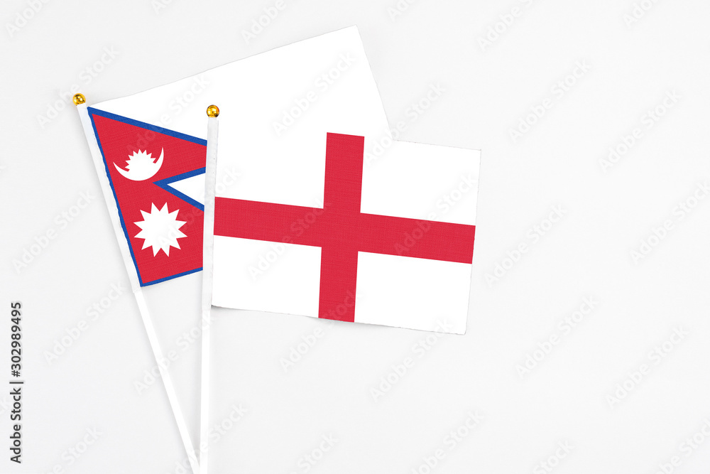 England and Nepal stick flags on white background. High quality fabric, miniature national flag. Peaceful global concept.White floor for copy space.