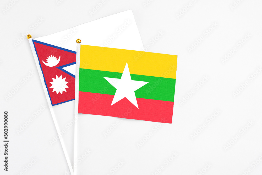Myanmar and Nepal stick flags on white background. High quality fabric, miniature national flag. Peaceful global concept.White floor for copy space. Myanmar and Nepal stick flags on white background. High quality fabric, miniature national flag. Peaceful global concept.White floor for copy space.