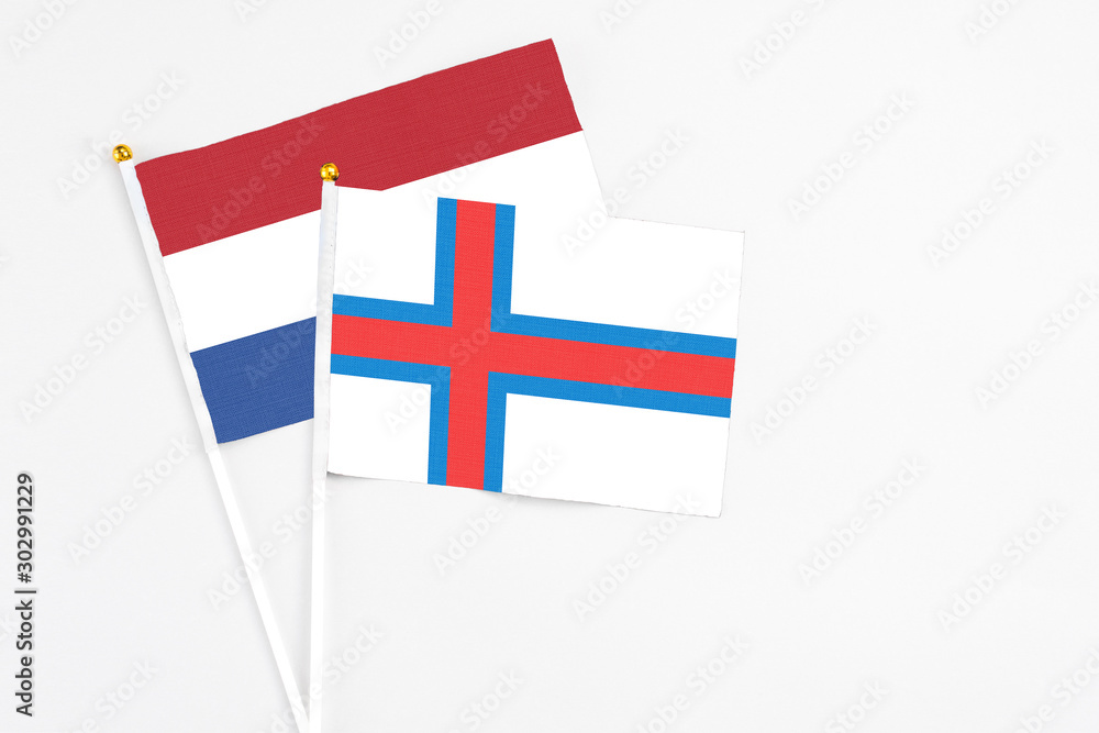 Faroe Islands and Netherlands stick flags on white background. High quality fabric, miniature national flag. Peaceful global concept.White floor for copy space.