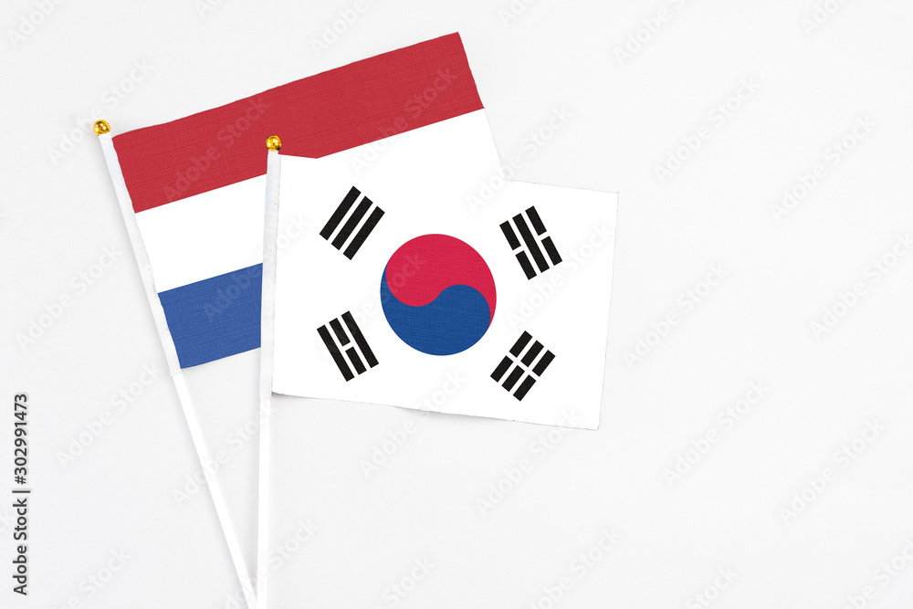 South Korea and Netherlands stick flags on white background. High quality fabric, miniature national flag. Peaceful global concept.White floor for copy space.