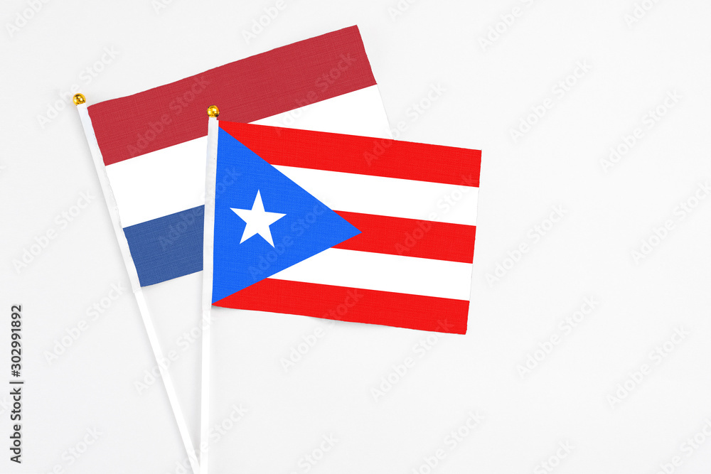 Puerto Rico and Netherlands stick flags on white background. High quality fabric, miniature national flag. Peaceful global concept.White floor for copy space. Puerto Rico and Netherlands stick flags on white background. High quality fabric, miniature national flag. Peaceful global concept.White floor for copy space.