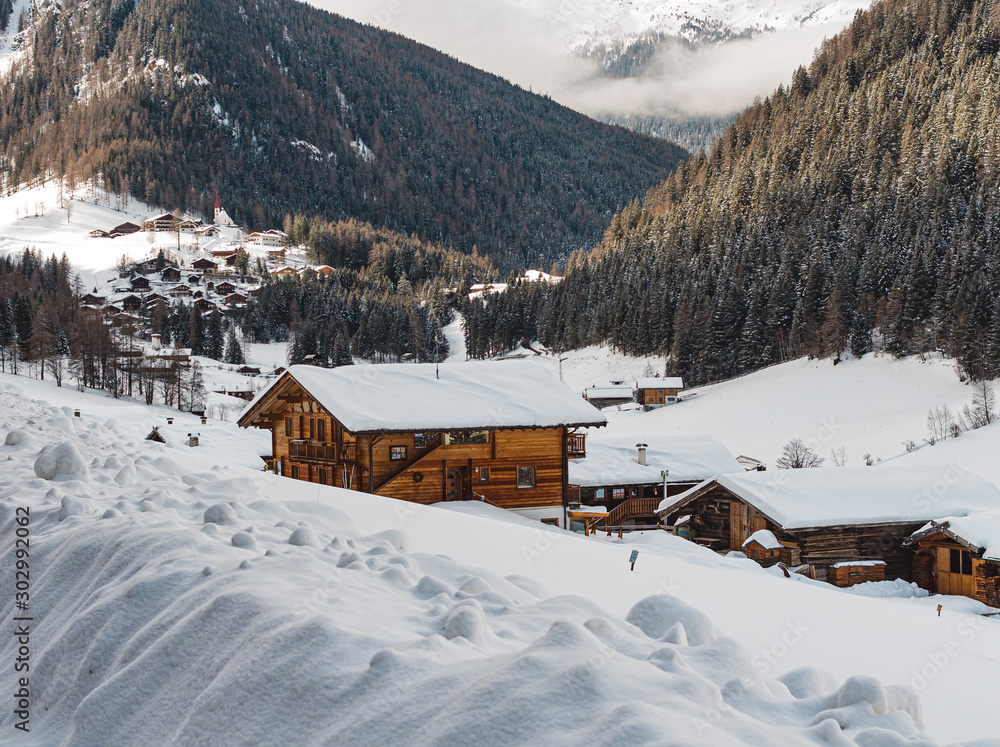 snow covered traditional wooden mountain huts in St. Gertraud (Ultental,South Tyrol/Italy) on cold Winter day 