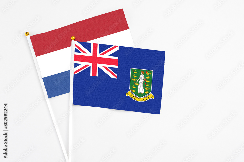 Fototapeta premium British Virgin Islands and Netherlands stick flags on white background. High quality fabric, miniature national flag. Peaceful global concept.White floor for copy space.