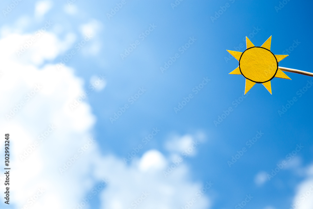 paper cut yellow sun on wooden stick on blue sky background paper cut yellow sun on wooden stick on blue sky background