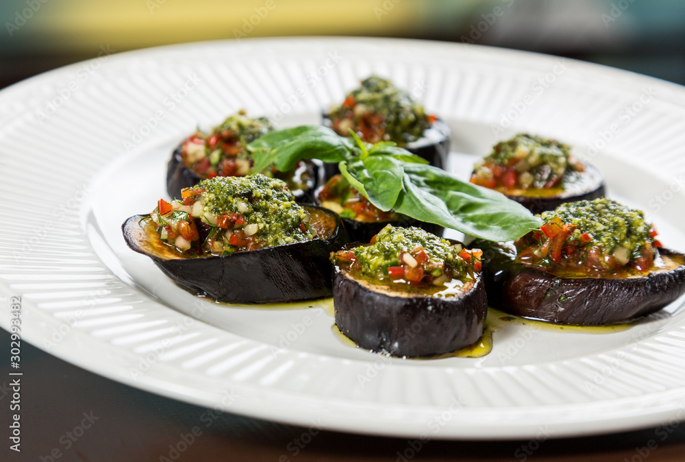 Backed aubergine slices with chopped vegetables topping