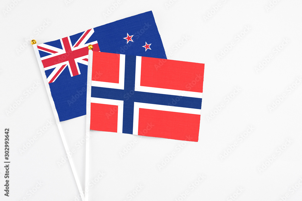 Fototapeta premium Bouvet Islands and New Zealand stick flags on white background. High quality fabric, miniature national flag. Peaceful global concept.White floor for copy space.