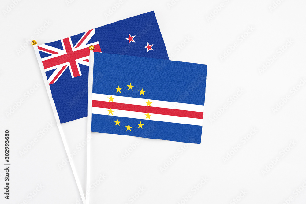 Fototapeta premium Cape Verde and New Zealand stick flags on white background. High quality fabric, miniature national flag. Peaceful global concept.White floor for copy space.