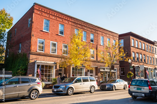 Renovated traditional American brick buildings with shops along a busy street in a downtown at sunset. Woodstock, VT, USA. photo
