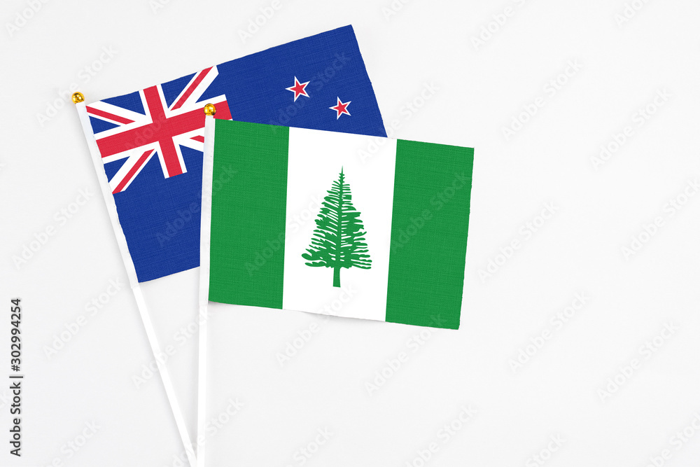 Norfolk Island and New Zealand stick flags on white background. High quality fabric, miniature national flag. Peaceful global concept.White floor for copy space. Norfolk Island and New Zealand stick flags on white background. High quality fabric, miniature national flag. Peaceful global concept.White floor for copy space.