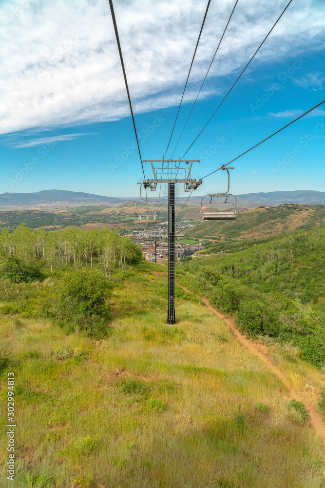 Focus on chairlifts against mountain sky and clouds in Park City at off season