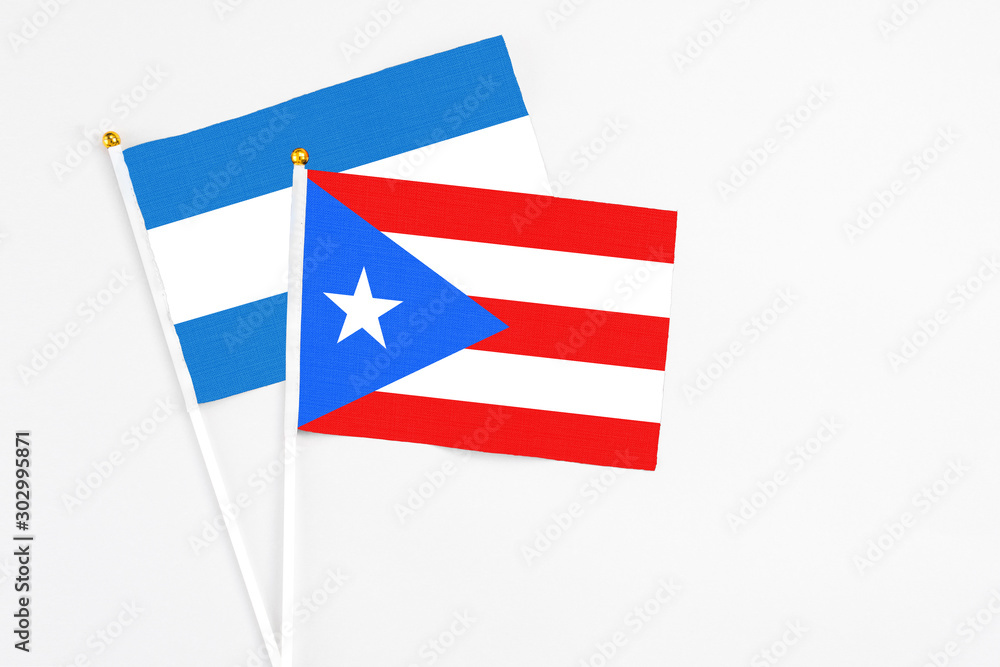 Puerto Rico and Nicaragua stick flags on white background. High quality fabric, miniature national flag. Peaceful global concept.White floor for copy space. Puerto Rico and Nicaragua stick flags on white background. High quality fabric, miniature national flag. Peaceful global concept.White floor for copy space.