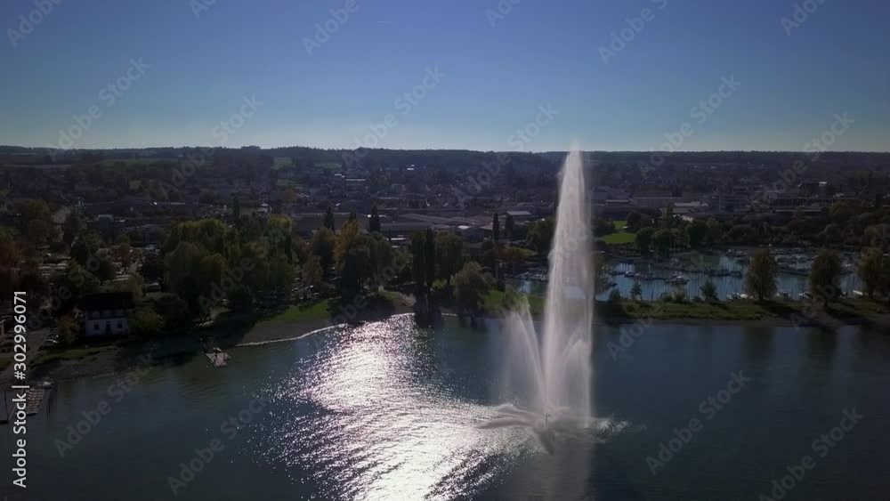 Aerial circle shot of a water fontaine on a sunny day at Lake Constance Aerial circle shot of a water fontaine on a sunny day at Lake Constance