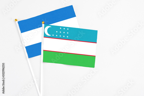 Free Download Uzbekistan and Nicaragua stick flags on white background. High quality fabric, miniature national flag. Peaceful global concept.White floor for copy space. - GFXLoad