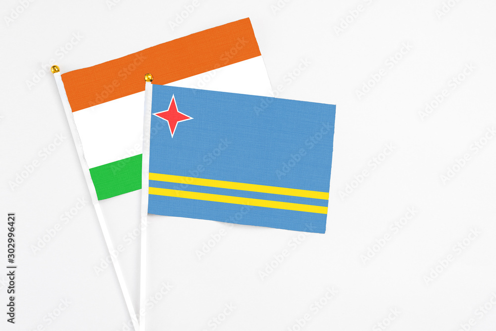Aruba and Niger stick flags on white background. High quality fabric, miniature national flag. Peaceful global concept.White floor for copy space. Aruba and Niger stick flags on white background. High quality fabric, miniature national flag. Peaceful global concept.White floor for copy space.