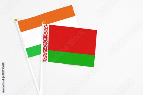 Belarus and Niger stick flags on white background. High quality fabric, miniature national flag. Peaceful global concept.White floor for copy space. photo