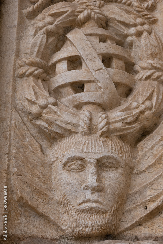 Architectural detail of frieze with face on old monastery 