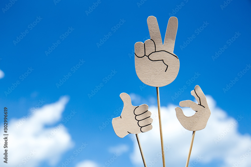 paper cut peace, okay and thumb up signs on sticks