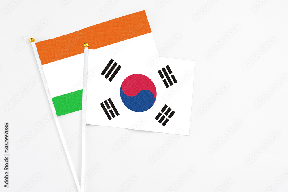 South Korea and Niger stick flags on white background. High quality fabric, miniature national flag. Peaceful global concept.White floor for copy space.