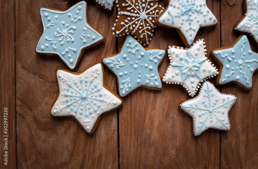 Homemade gingersnaps covered with icing on the wooden background; delicious cookies with Christmas shapes Homemade gingersnaps covered with icing on the wooden background; delicious cookies with Christmas shapes