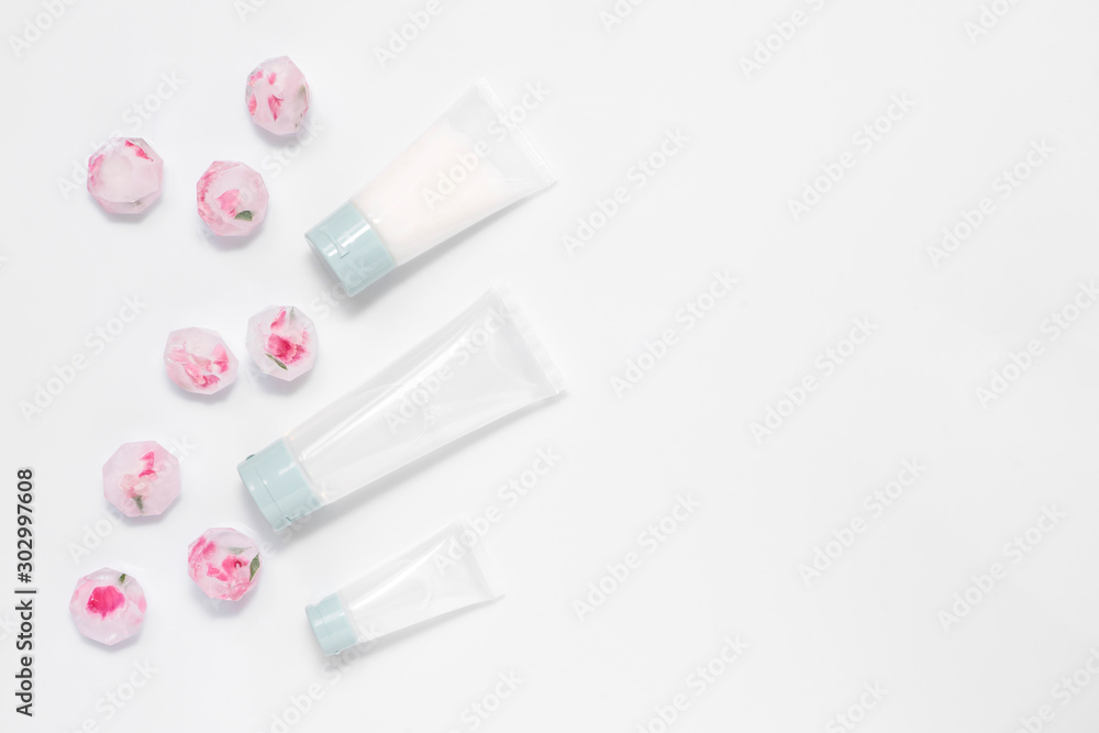 Recipe of youth, face care treatment, cream transparent tubes, ice cubes with herbs and flowers isolated on white background. Flat lay, top view, copy space. Beauty therapy products concept Recipe of youth, face care treatment, cream transparent tubes, ice cubes with herbs and flowers isolated on white background. Flat lay, top view, copy space. Beauty therapy products concept