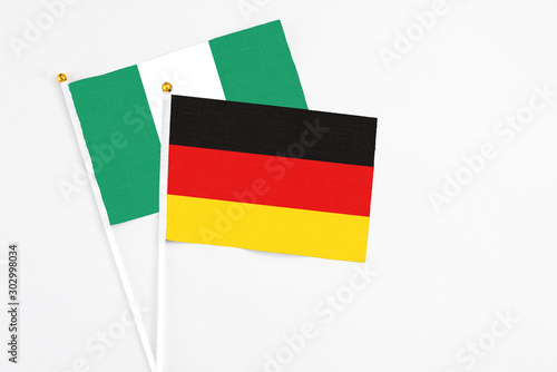 Germany and Nigeria stick flags on white background. High quality fabric  miniature national flag. Peaceful global concept.White floor for copy space.