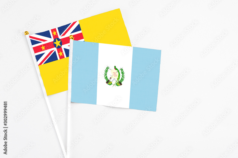 Guatemala and Niue stick flags on white background. High quality fabric, miniature national flag. Peaceful global concept.White floor for copy space. Guatemala and Niue stick flags on white background. High quality fabric, miniature national flag. Peaceful global concept.White floor for copy space.